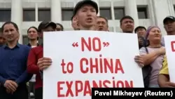 Участник антикитайской акции в Алматы держит плакат с надписью «Нет китайской экспансии». 4 сентября 2019 года.