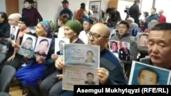 Люди на пресс-конференции в Нур-Султане с фотографиями родственников, удерживаемых, по их словам, под стражей в Китае. 27 ноября 2019 года.