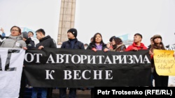 Активисты молодежного движения «Oyan, Qazaqstan» с плакатами у монумента Независимости. Алматы, 16 декабря 2019 года.