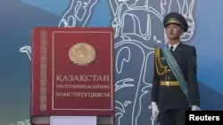 Военнослужащий рядом с макетом книги с надписью «Конституция Республики Казахстан». Алматы, 30 августа 2014 года.