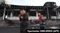 Подростки на фоне сожженного здания в селе Масанчи. Жамбылская область, 8 февраля 2020 года.