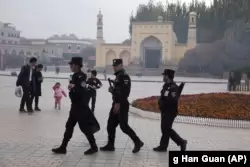 Патруль спецподразделения китайской полиции безопасности на площади перед мечетью Ид Ках в Кашгаре.